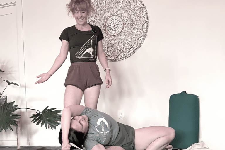 Yoga instructor guiding a student with hands-on support during an Iyengar-style practice